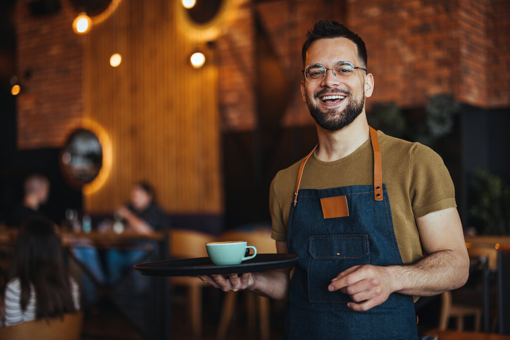 Waiter serving coffee in a Croatian café